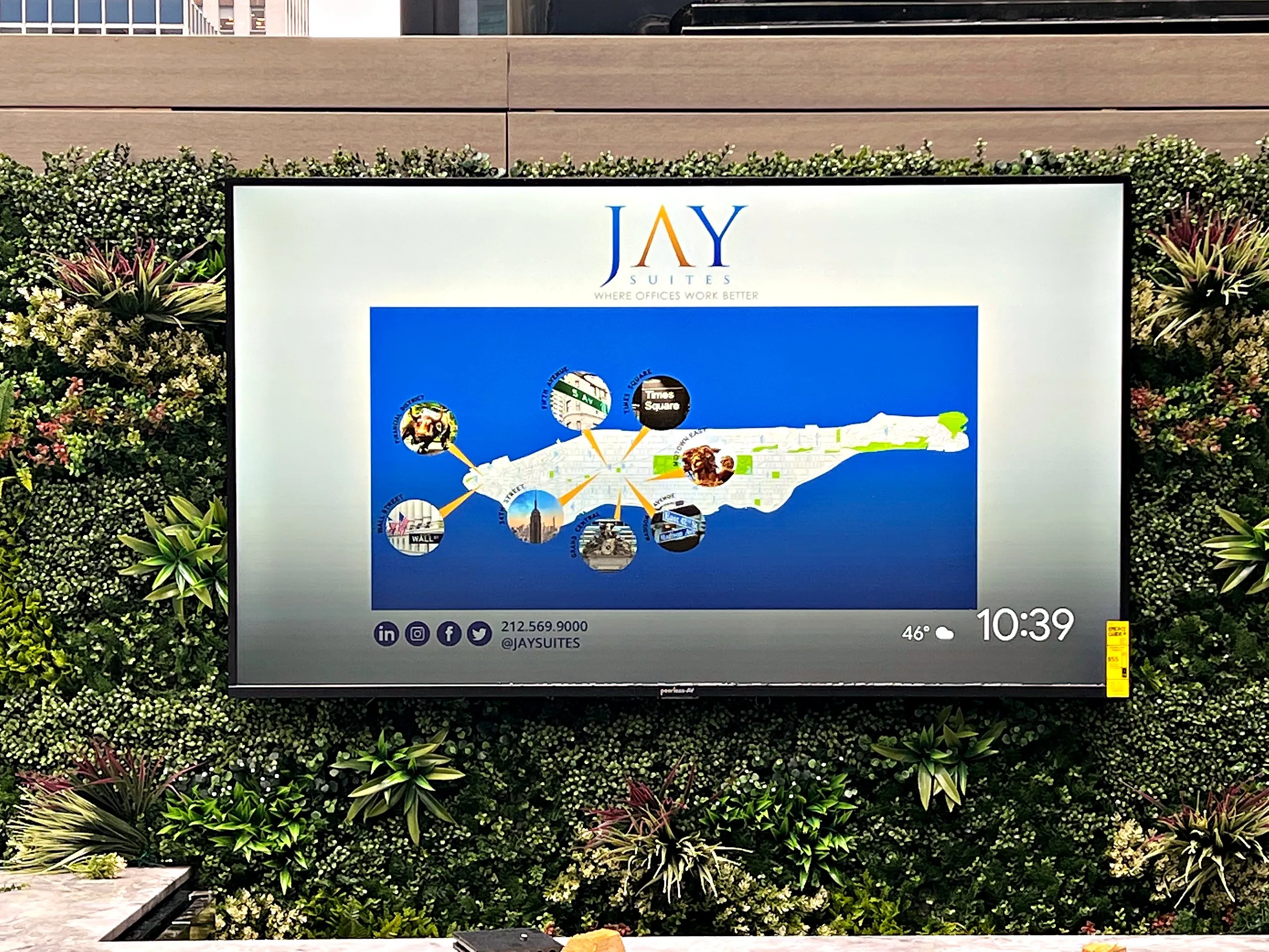 Outdoor display mounted on a green wall